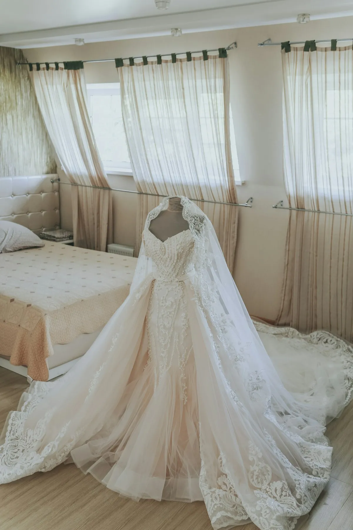 Vestido de noiva com renda e cauda longa, exposto antes da cerimônia